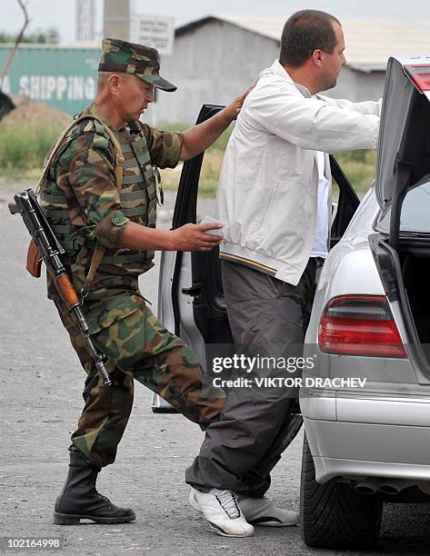 Kyrgyzs special police officer searches a driver at a check point in Osh on June 17, 2010. Deadly inter-ethnic clashes that erupted in Kyrgyzstan a...