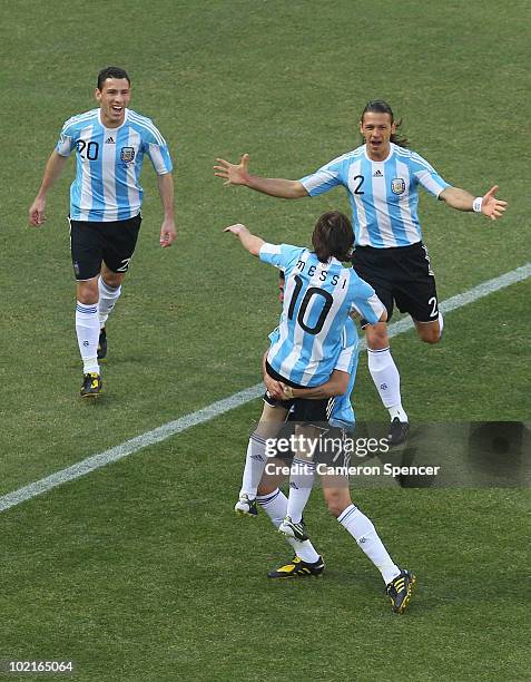 Lionel Messi of Argentina is lifted up by Angel Di Maria as they celebrate with team mates an own goal by Park Chu-Young of South Korea during the...