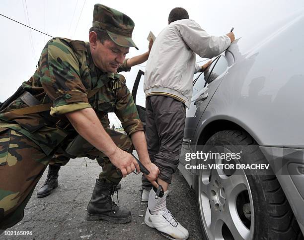 Kyrgyzs special police officer discovers a pistol during a search on a driver at a check point in Osh on June 17, 2010. Deadly inter-ethnic clashes...