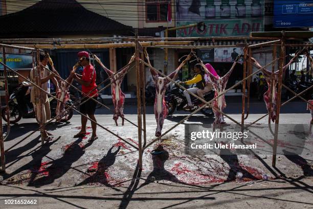 Indonesian Muslims butchers goats during celebrations for Eid al-Adha in Masbagig on August 23, 2018 in Lombok island, Indonesia. Thousands of...