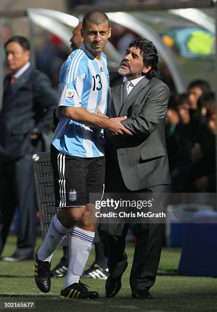 Diego Maradona head coach of Argentina consoles the injured Walter Samuel during the 2010 FIFA World Cup South Africa Group B match between Argentina...