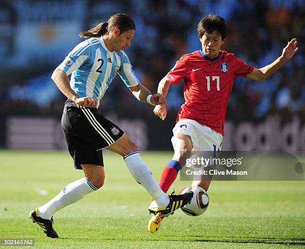 Martin Demichelis of Argentina clashes with Lee Chung-Yong of South Korea during the 2010 FIFA World Cup South Africa Group B match between Argentina...
