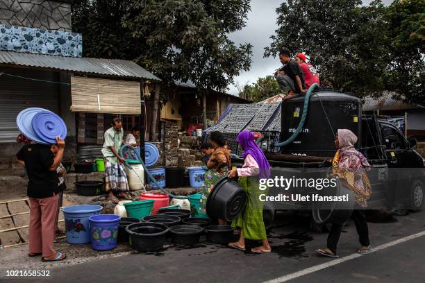 Villagers queue to fill water in Sajang village on August 23, 2018 in Lombok island, Indonesia. Thousands of residents remain stranded at the...