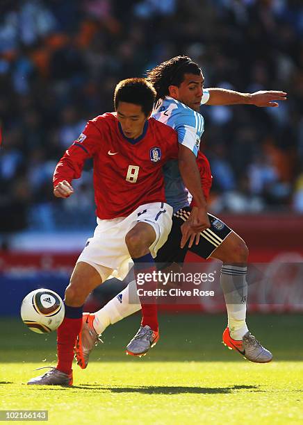 Kim Jung-Woo of South Korea attempts to hold back Carlos Tevez of Argentina during the 2010 FIFA World Cup South Africa Group B match between...