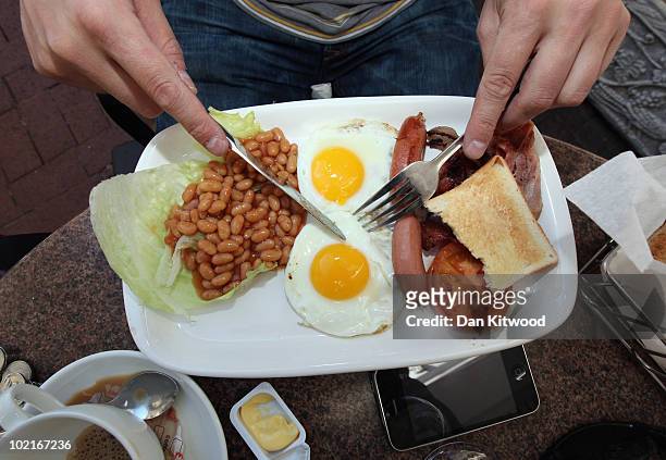 An England fan eats an full English breakfast on June 17, 2010 in Cape Town, South Africa. Cape Town hosts the match between England and Algeria in...
