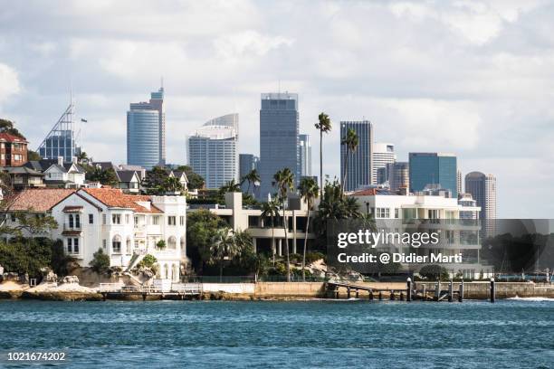 luxury real estate along the sydney bay coast with the city business district skyline in sydney, australia largest city. - coastal feature stock pictures, royalty-free photos & images