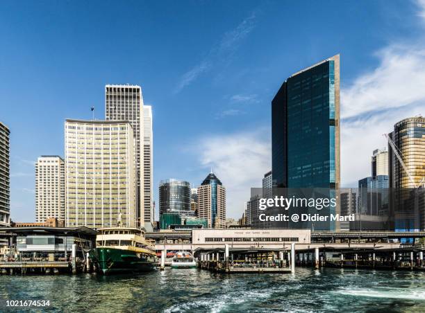 stunning view of the circular quay ferry terminal with boats in front of the downtown district of sydney with its skyscrapers on a sunny day - circular quay stock pictures, royalty-free photos & images