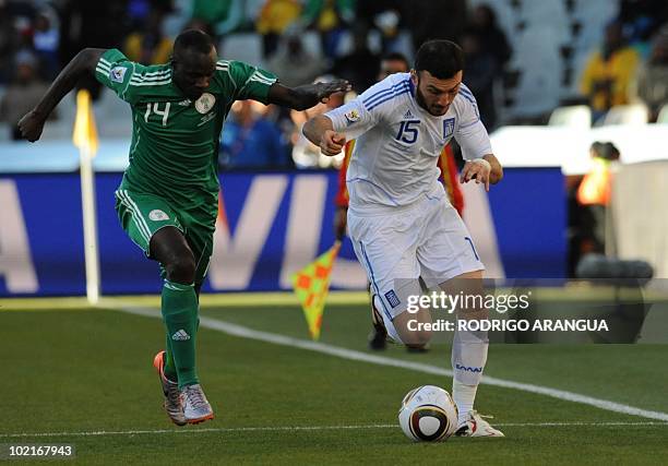 Nigeria's midfielder Sani Kaita challenges Greece's defender Vasilis Torosidis for the ball during the Group B first round 2010 World Cup football...