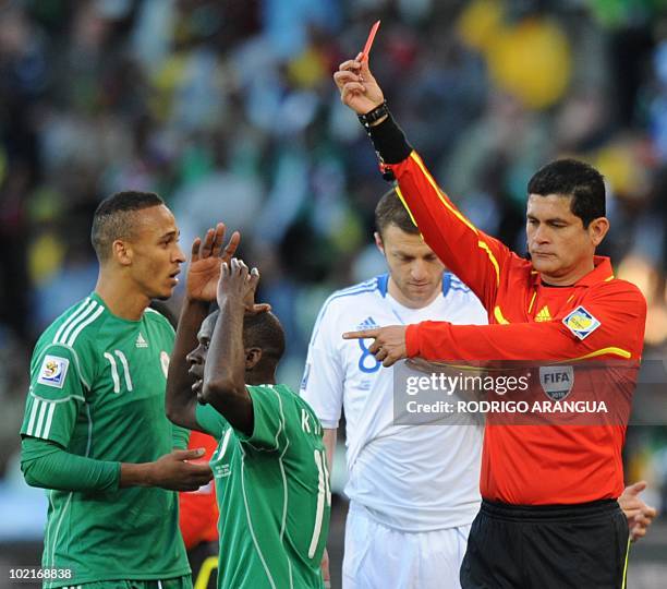 Colombian referee Oscar Ruiz hands a red card to Nigeria's midfielder Sani Kaita after the latter kicked Greece's defender Vasilis Torosidis during...