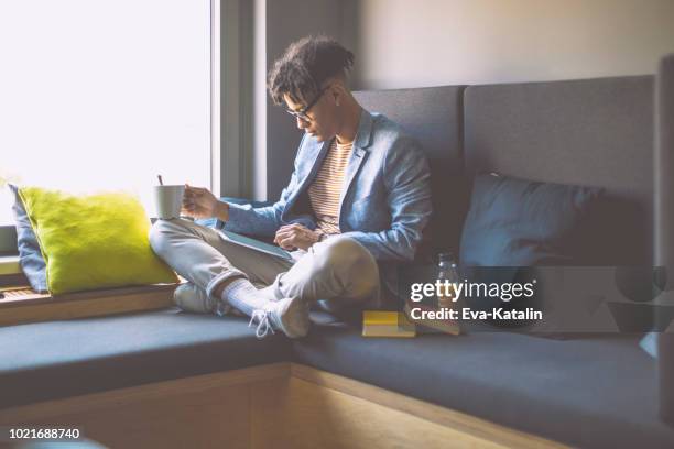 young man is taking a break in a cosy corner - hipster coffee shop candid stock pictures, royalty-free photos & images