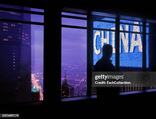 window with man looking at large china neon sign - tillväxtmarknad bildbanksfoton och bilder