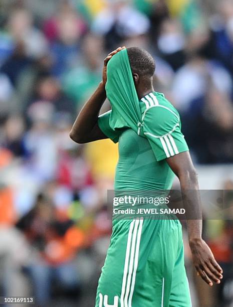 Nigeria's midfielder Sani Kaita hides his face after being handed a red card for kicking Greece's defender Vasilis Torosidis during the Group B first...