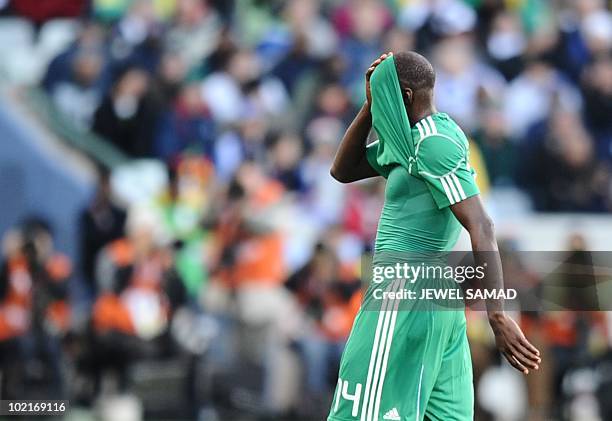 Nigeria's midfielder Sani Kaita hides his face after being handed a red card for kicking Greece's defender Vasilis Torosidis during the Group B first...