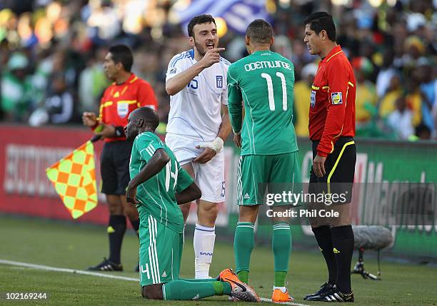 Vassilis Torosidis of Greece argues with Peter Odemwingie of Nigeria as he shows the marks on his leg after a tackle by Sani Kaita of Nigeria, who...