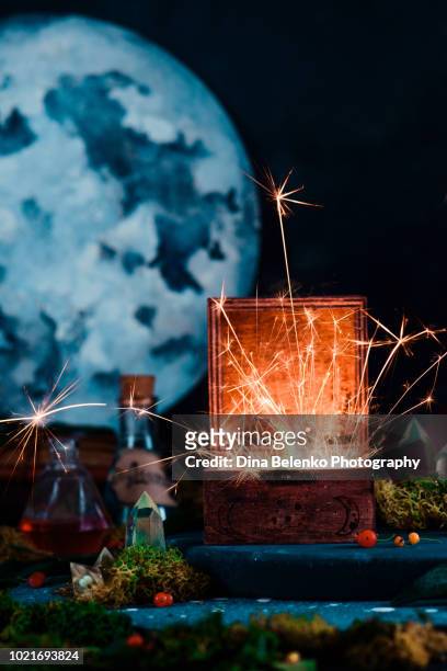 wooden box with a flame inside. magical still life with alchemical equipment, astrologer workplace with a sealed star. sparkler photography with copy space - wicca stock-fotos und bilder