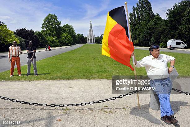 Man holds the Belgian flag at Laken royal castle on June 17, 2010 in Brussels, four days after the federal elections. King Albert II took the first...