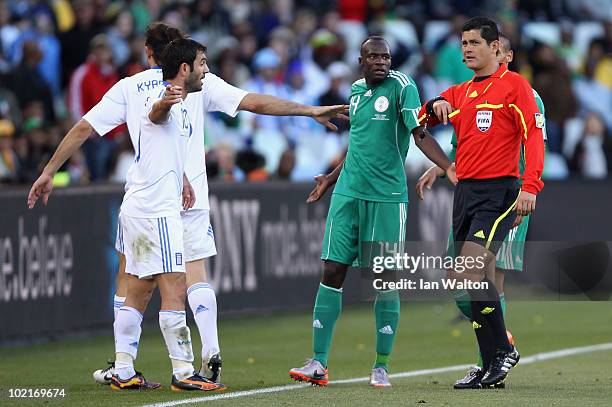 Sani Kaita of Nigeria pleads his innocence to referee Oscar Ruiz as he goes into his pocket to show a red card to Kaita during the 2010 FIFA World...