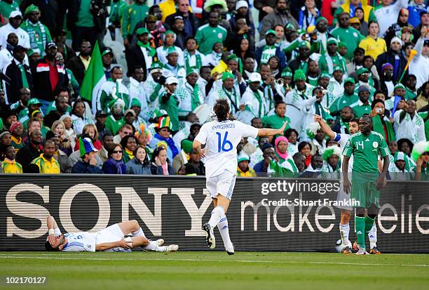 Vassilis Torosidis of Greece lies on the ground after being tackled by Sani Kaita of Nigeria , who is sent off for the challenge during the 2010 FIFA...