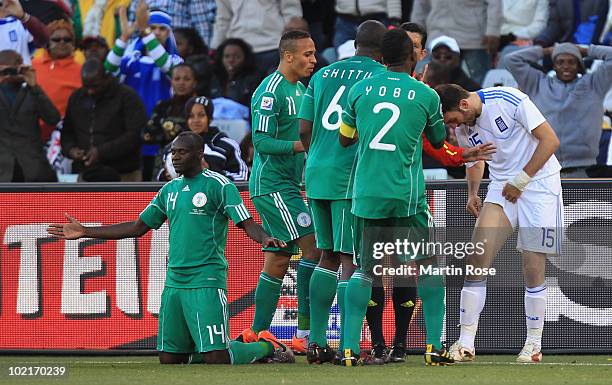 Vassilis Torosidis of Greece shows Nigeria players the mark on his leg after a tackle by Sani Kaita of Nigeria, who kneels on the ground after being...