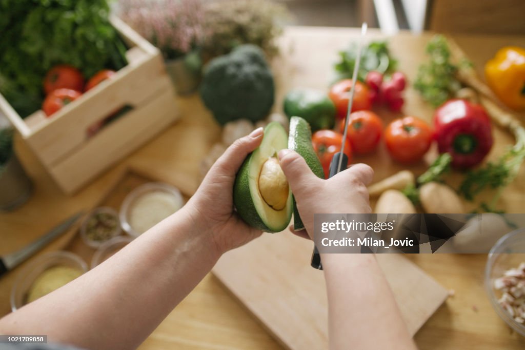 Uomo che prepara il pasto vegano in cucina domestica