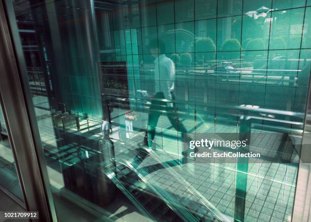 reflection of city life in window of modern office building - green glass business stock-fotos und bilder