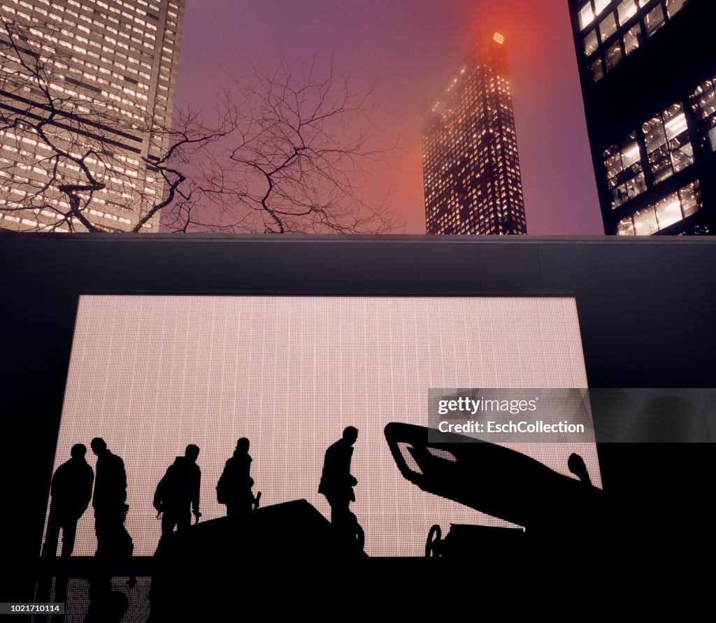 People looking at temporary car display in front of illuminated skyline