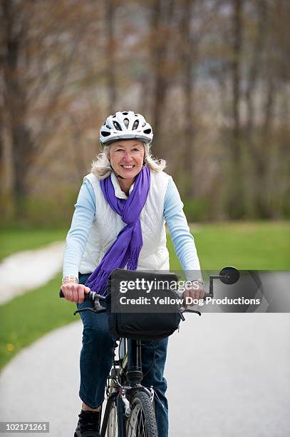 senior woman wearing a bike helmet riding bike - manchester vermont foto e immagini stock