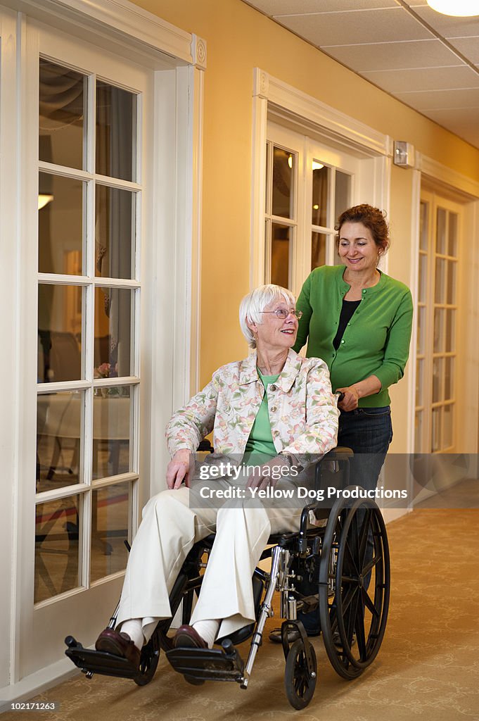 Caregiver helping senior woman in wheelchair