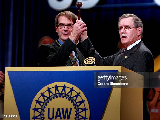 Ron Gettelfinger, outgoing United Auto Workers union president, right, passes the gavel to his successor, Bob King, during the UAW 35th...