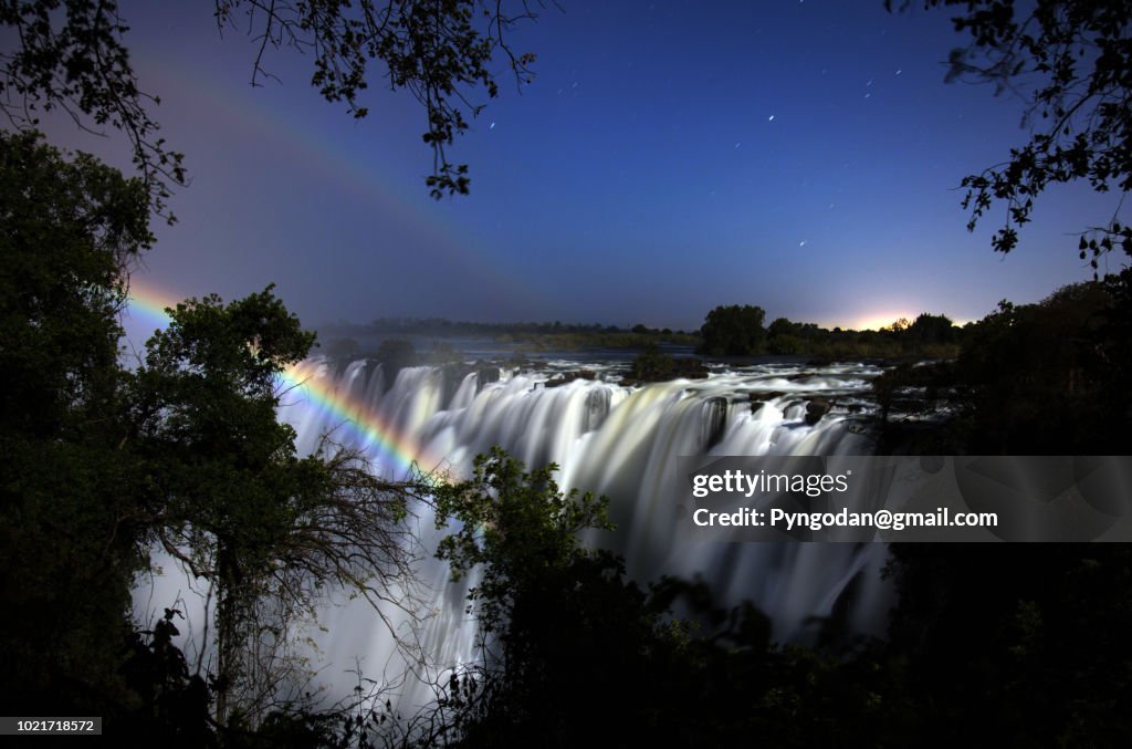 Moonbow appearing over the Victoria falls at night at Zambia