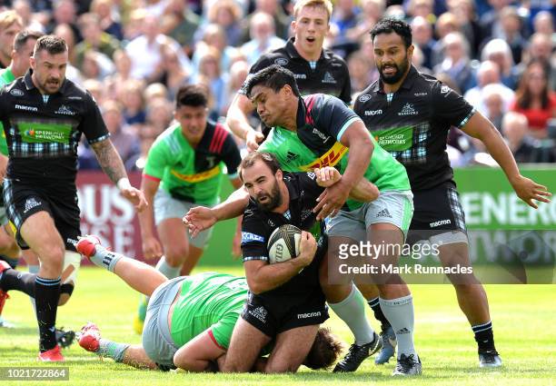 Nick Frisby of Glasgow Warriors is tackled by Stan South and Ben Tapuai of Harlequins during the Famous Grouse Pre-Season Challenge between Glasgow...