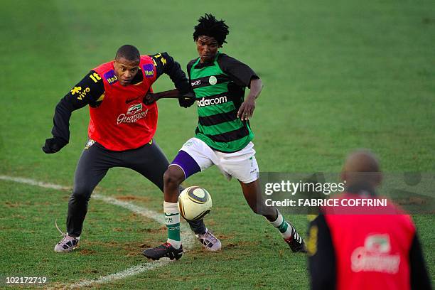 Brazil's midfielder Julio Baptista vies for the ball with a members of the under-19 team "The Birds" from Vaal during a training session at the...