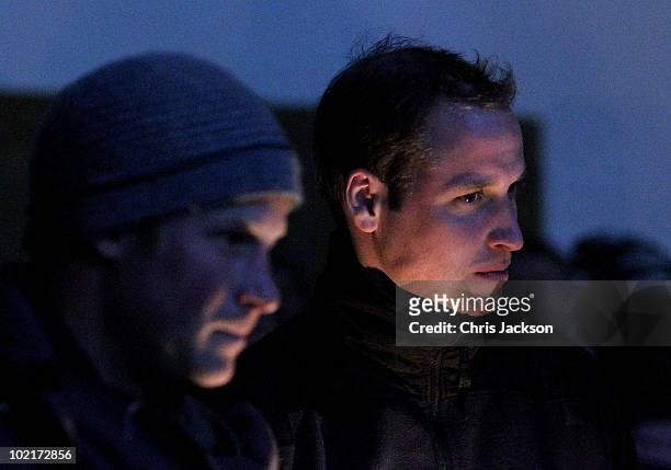 Prince Harry and Prince William look on in the faint candlelight as they visit Semonkong Herd Boy School on June 16, 2010 in Semonkong, Lesotho. The...