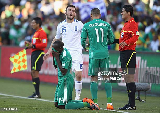 Sani Kaita of Nigeria covers his face after being shown a red card as team mate Peter Odemwingie argues with Vassilis Torosidis of Greece during the...