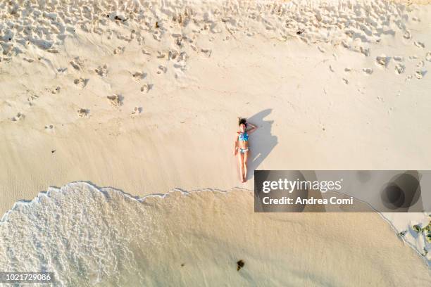 aerial view of a beautiful woman sunbathing - beach bird's eye perspective imagens e fotografias de stock