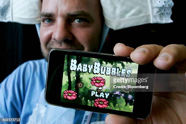 Steven "Goody" Goodale displays an Apple iPhone loaded with "Baby Bubbles," a game he developed for iPhones, iPads, and the iPod Touch, during the...