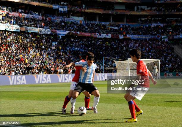 Sergio Aguero of Argentina is held by Oh Beom-Seok of South Korea during the 2010 FIFA World Cup South Africa Group B match between Argentina and...