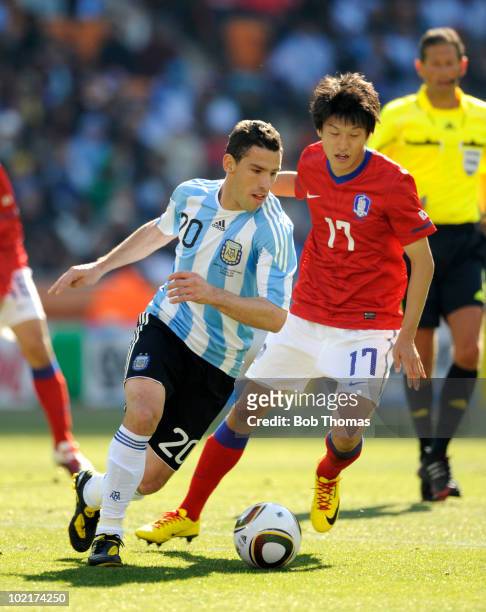 Maxi Rodriguez of Argentina is watched by Lee Chung-Yong of South Korea during the 2010 FIFA World Cup South Africa Group B match between Argentina...