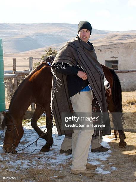 Prince William, wearing a blanket to keep out the cold, arrives at the Semongkong Children's Centre on June 17, 2010 in Semongkong, Lesotho. The...