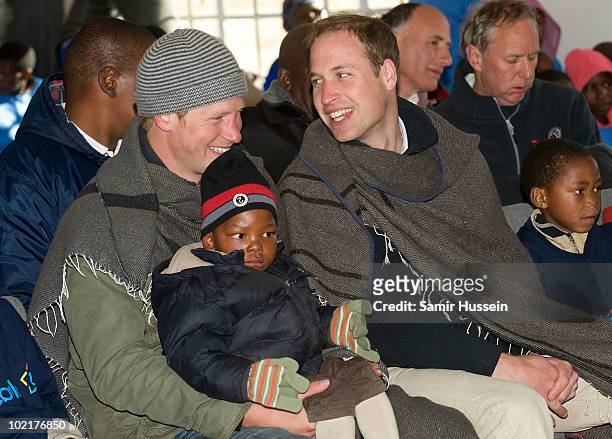 Prince Harry holds a young boy on his knee as he and Prince William visit the Semongkong Children's Centre on June 17, 2010 in Semongkong, Lesotho....