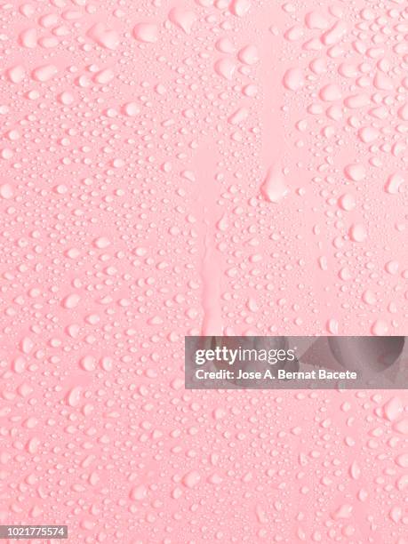 full frame of the textures formed by the bubbles and drops of water, slipping on the crystal of a window of color pale pink. - gota a gota fotografías e imágenes de stock