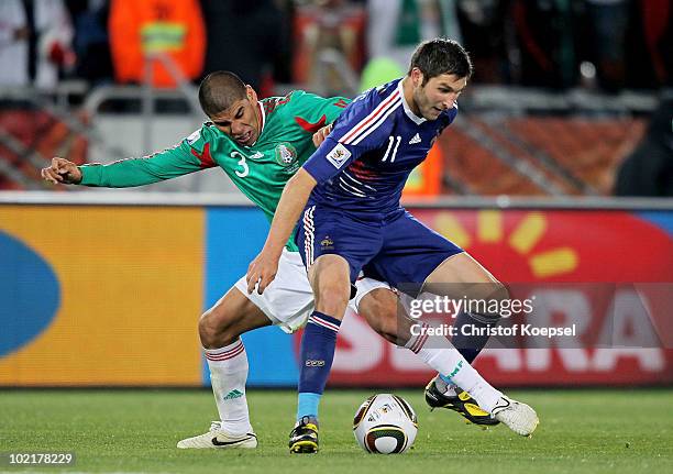 Carlos Salcido of Mexico tackles Andre Pierre Gignac of France during the 2010 FIFA World Cup South Africa Group A match between France and Mexico at...