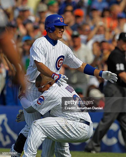 Kosuke Fukudome of the Chicago Cubs is lifted by teammate Marlon Byrd after getting the game-winning hit in the bottom of the 9th inning against the...