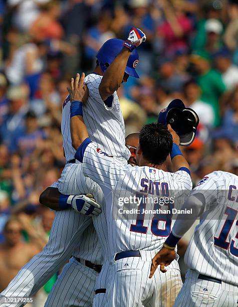 Kosuke Fukudome of the Chicago Cubs celebrates his game-winning hit in the bottom of the 9th inning against the Oakland Athletics with teammates...