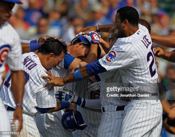 Kosuke Fukudome of the Chicago Cubs is mobbed by teammates including Geovany Soto and Derrick Lee after getting the game-winning hit in the bottom of...