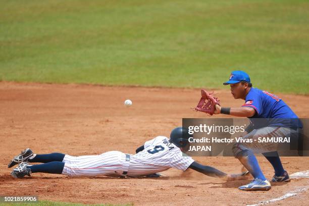 Isshin Obata of Japan slides safely into first base against Chan-I Li of Chinese Taipei in the 2nd inning during the Bronze Medal match of WSBC U-15...