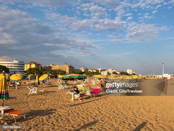 bibione - beach and umbrellas at sunset - bibione stock pictures, royalty-free photos & images