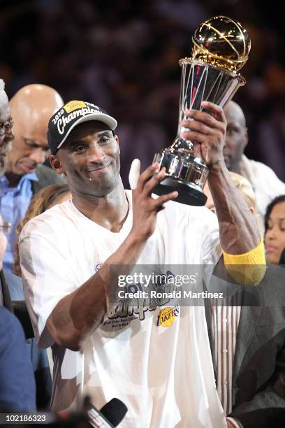 Kobe Bryant of the Los Angeles Lakers holds up the Bill Russell Finals MVP trophy after the Lakers defeated the Boston Celtics 83-79 in Game Seven of...