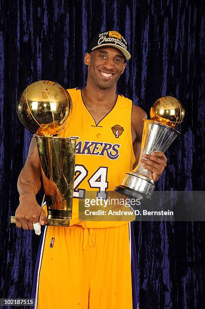 Kobe Bryant of the Los Angeles Lakers holds the Larry O'Brien Trophy and the Bill Russell MVP Trophy following his team's victory over the Boston...