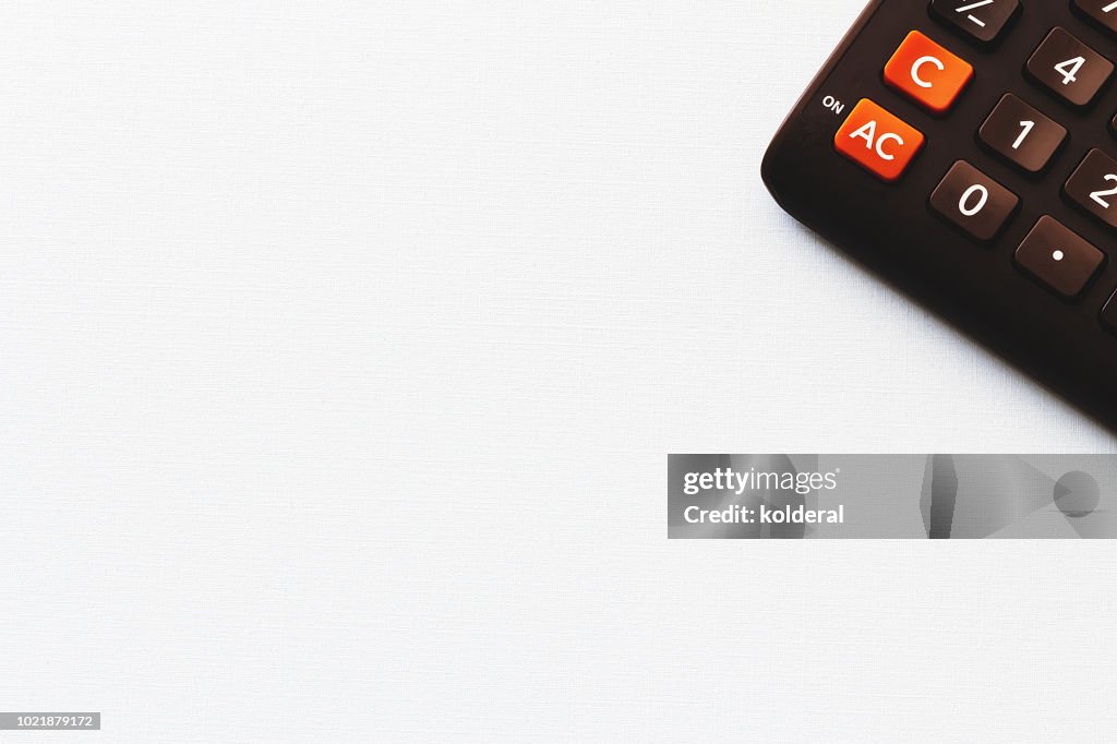 Calculator on white textured background , copy space